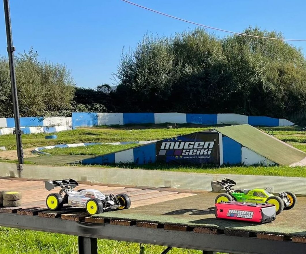 RC Autos in der Boxengasse mit der Rennstrecke im Hintergrund